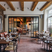 Cozy restaurant interior featuring warm wood tones, leather seating, and a mix of neutral and earthy color palettes.