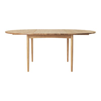 Natural wood oval dining table with a smooth grain finish and light oak color, complemented by sleek wooden legs.