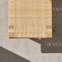 Light natural bamboo texture with intricate woven patterns and subtle wood accents against a warm concrete background.