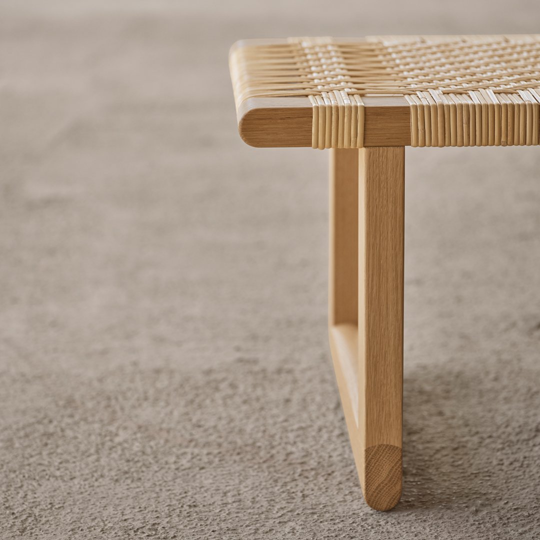 Natural wood tones with woven light beige pattern panel, minimalist design on a neutral gray surface.