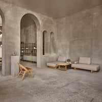 Minimalist gray concrete interior with soft beige furniture and natural wood accents, featuring smooth textures and clean lines.