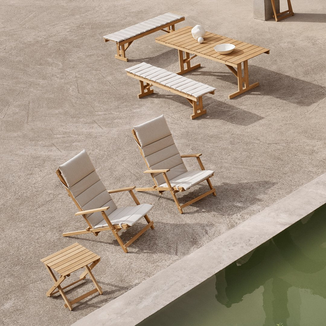 Gray striped outdoor chairs with natural wood frames, paired with matching wooden tables, on a textured concrete surface.