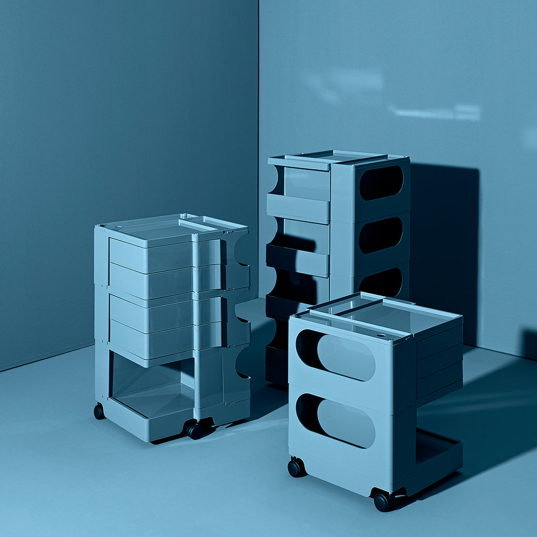Blue storage carts with sleek designs and unique circular and rectangular cutouts, arranged on a matching blue background.