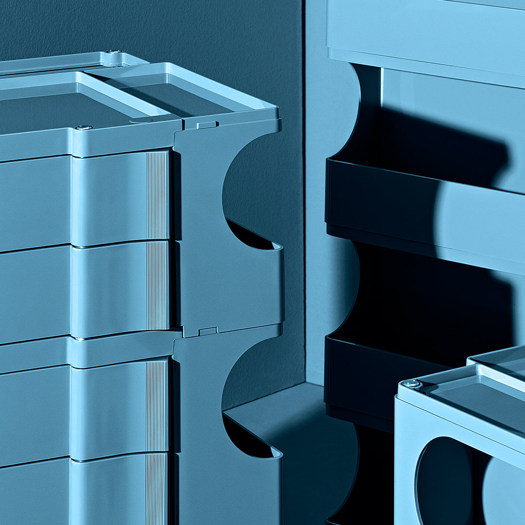 Stacked storage bins in soft blue shades with sleek, smooth patterns and contrasting dark accents.