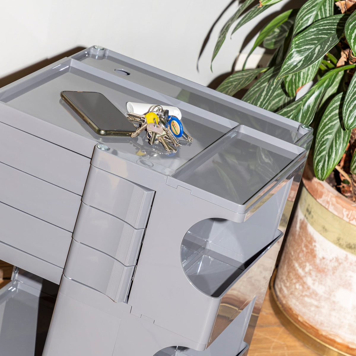 Gray multi-drawer storage unit with sleek, modern design and transparent details on a minimalist background.