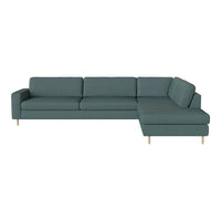 Teal sectional sofa with clean lines, plush cushions, and light wooden legs, perfect for modern decor.