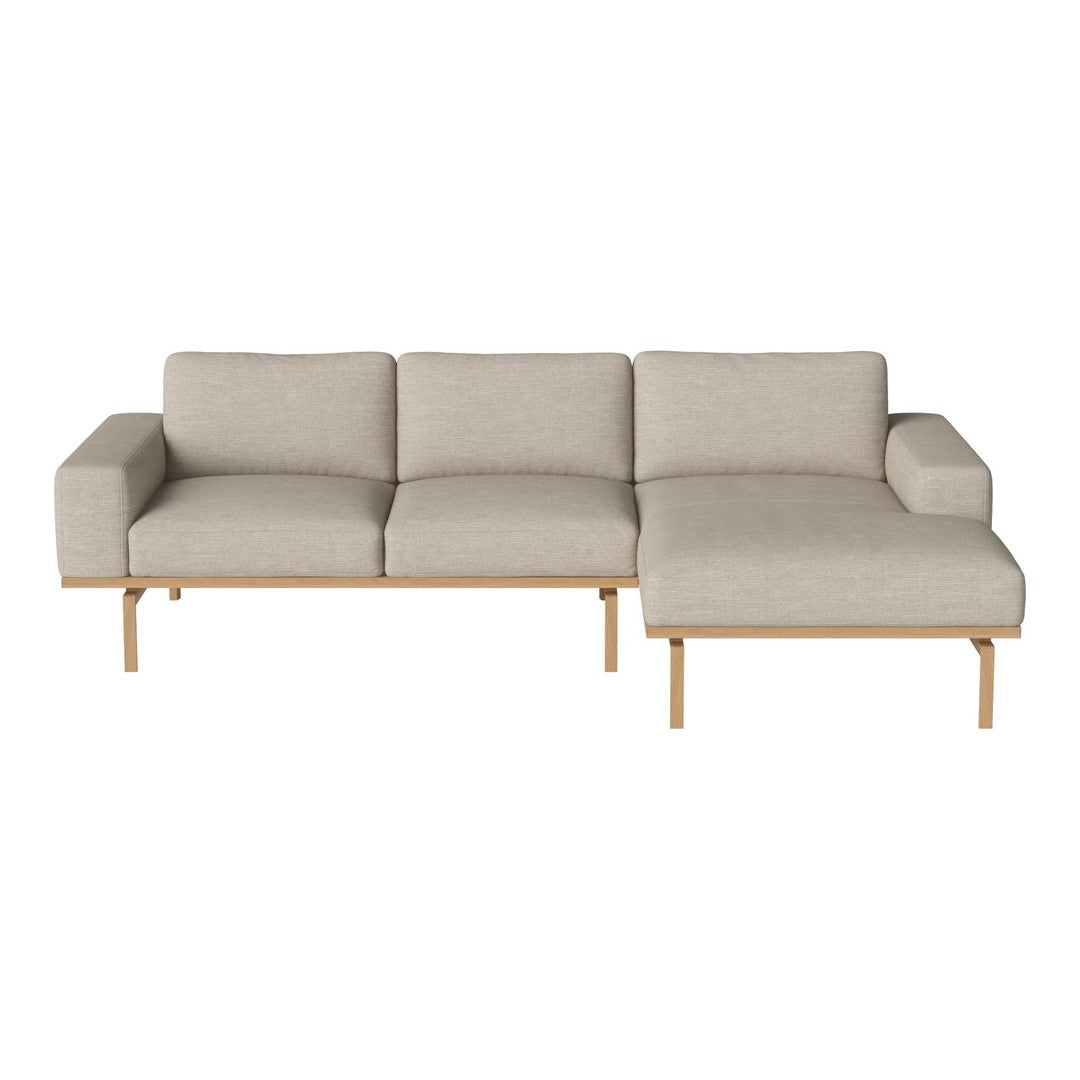 Light beige sectional sofa with a minimalist design and natural wood legs, featuring a smooth, textured fabric.