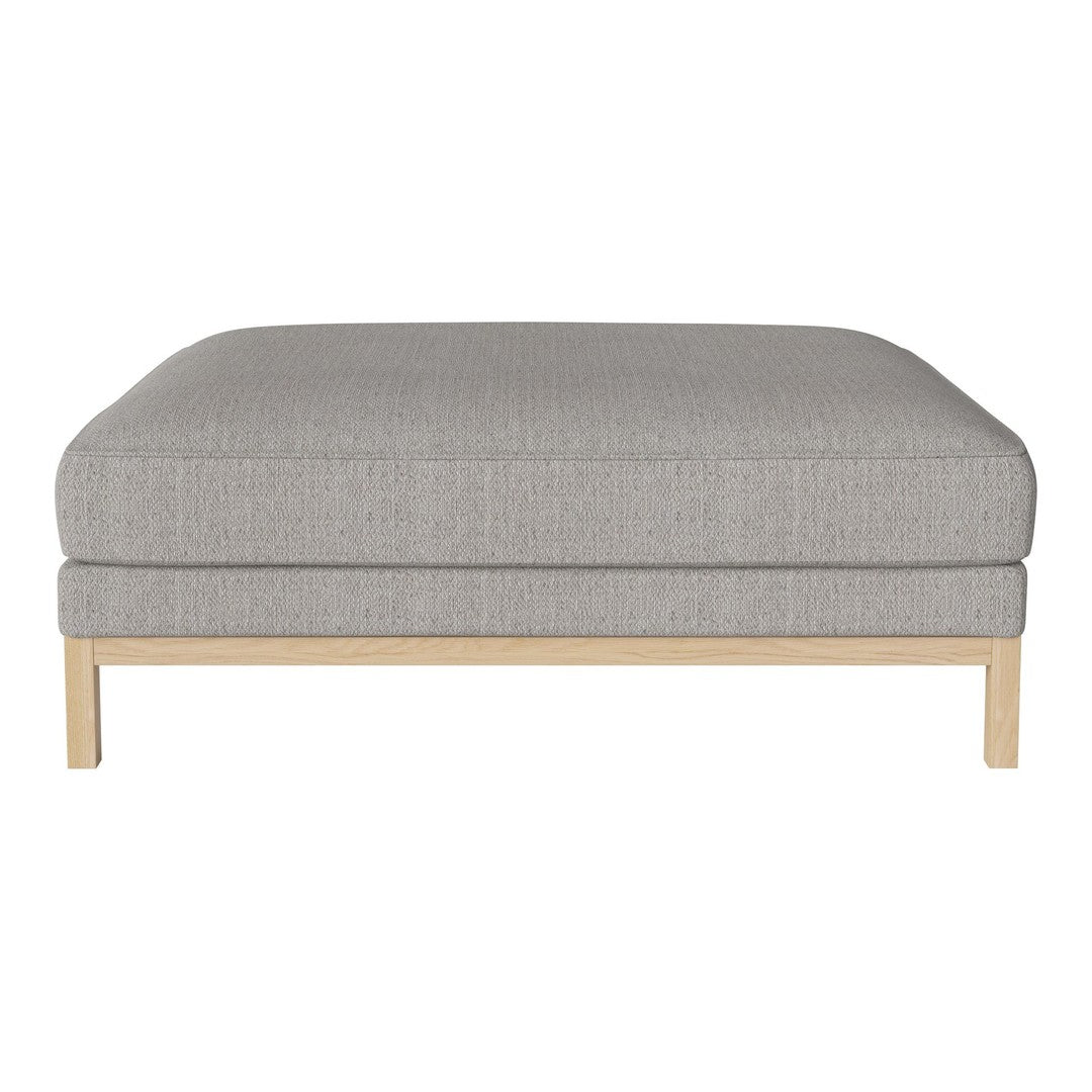 Gray upholstered ottoman with a subtle texture, resting on a light wood frame. Perfect for modern decor.
