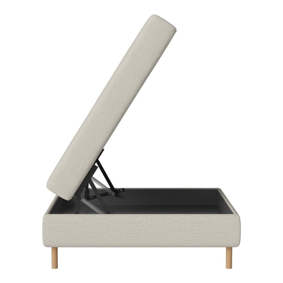 Beige upholstered sofa with a lift-top design and sleek black interior, showcasing natural wood legs.