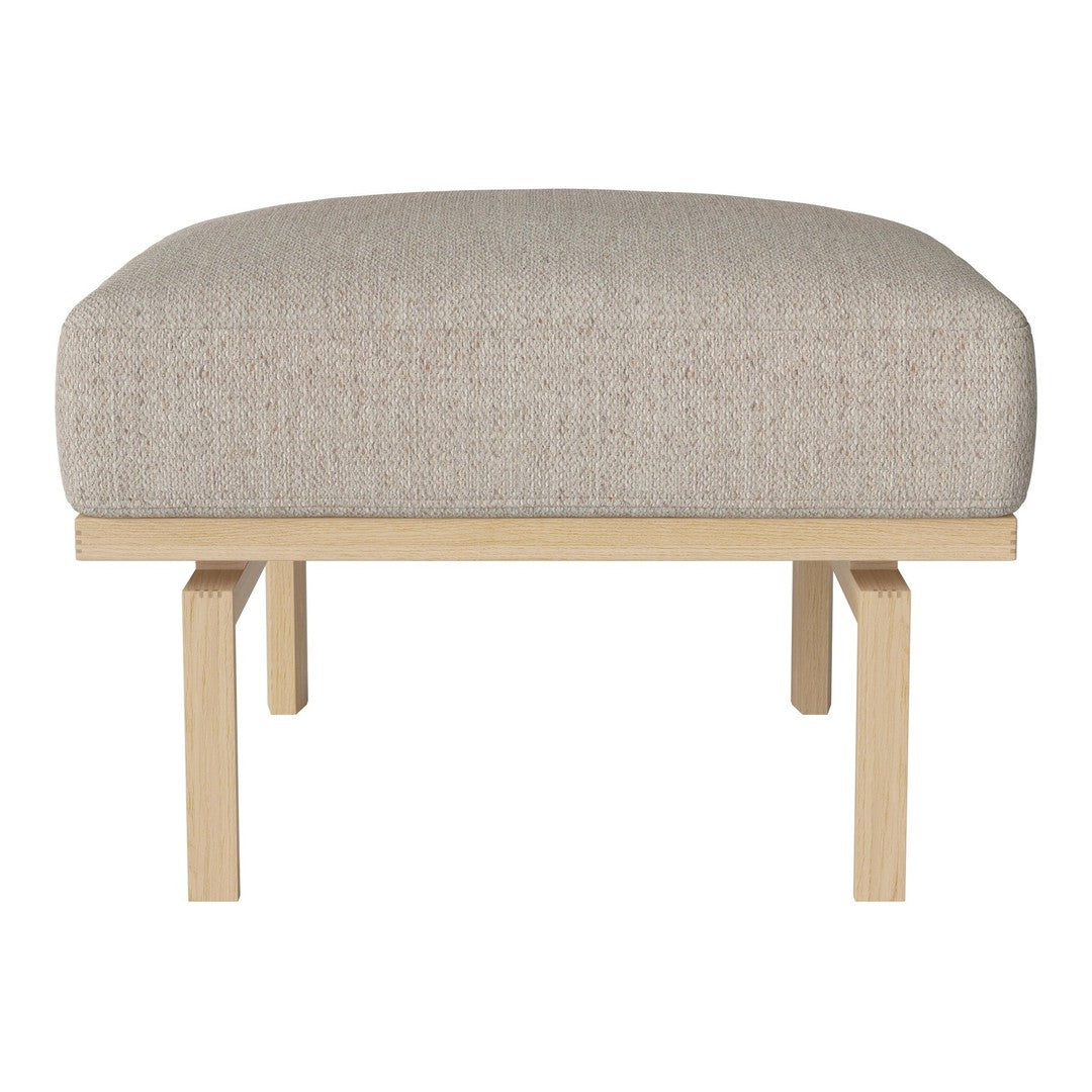 Beige upholstered ottoman with subtle textured fabric and natural wood legs. Ideal for modern living spaces.
