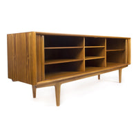 Mid-century modern wooden media console in warm walnut finish, featuring a sleek design and open shelving.