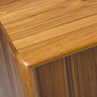 Close-up of a warm golden-brown wood surface showcasing fine, natural stripes and a smooth finish.