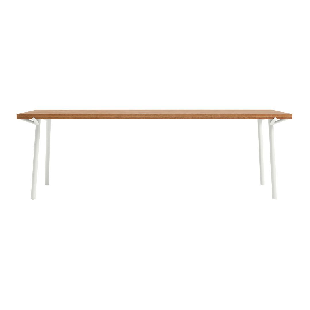 Modern wooden table with a warm brown finish and sleek white legs, featuring a minimalist design.