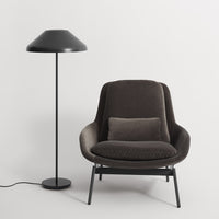 "Stylish dark gray armchair with a subtle texture, paired with a sleek black floor lamp against a minimalistic background."