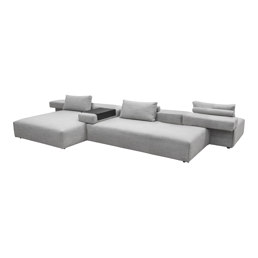 Grey sectional sofa with sleek, modern lines and soft fabric upholstery, featuring minimalist design and subtle texture.