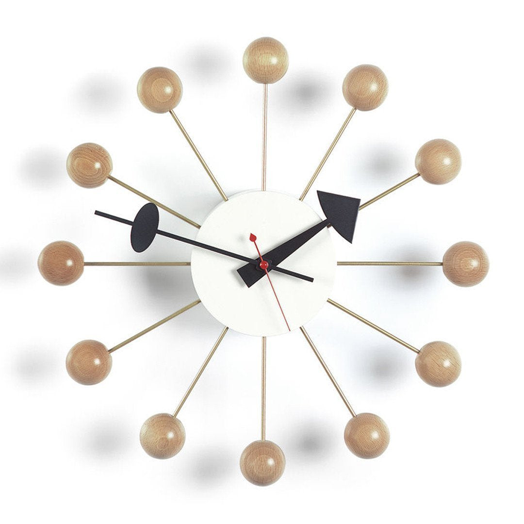 Modern wall clock featuring a white face, black hands, and natural wood accents in a radial pattern.