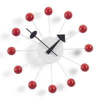 Retro wall clock with red spheres and white rods, featuring a sleek black clock face and hands.