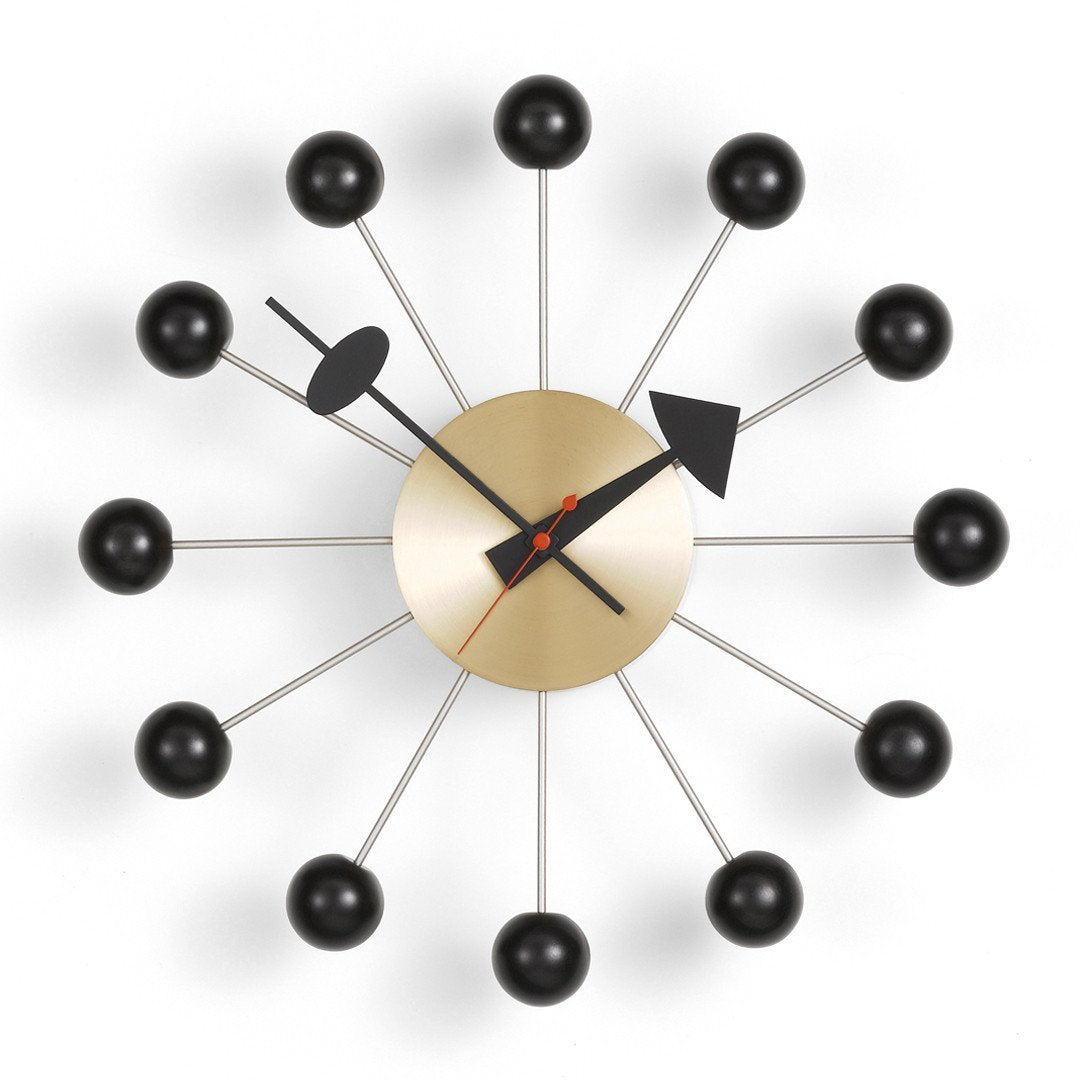 Mid-century modern wall clock featuring a gold face, black accents, and red hands against a white background.
