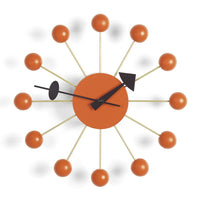 Mid-century modern wall clock in orange with black accents and golden hour markers, featuring playful round designs.