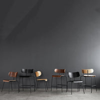 Set of modern chairs featuring warm wood tones and sleek black metal accents against a dark gray backdrop.