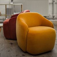 Yellow and red modern accent chairs with soft, curved shapes and plush upholstery on wooden floor background.