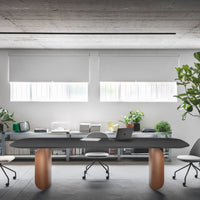 Modern office with a sleek black table, white chairs, and warm copper accents against a minimalist gray background.