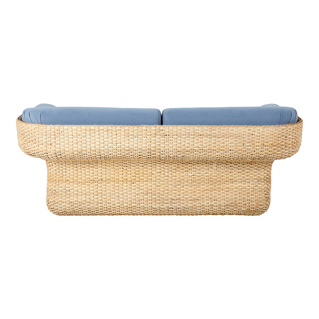 Woven rattan sofa in natural beige with soft blue cushions, featuring a modern, minimalist design.