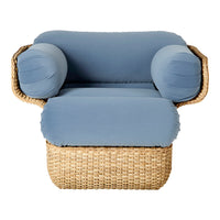 Light blue upholstered chair with woven rattan base and rounded armrests for a cozy, stylish look.