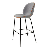 Gray upholstered bar stool with black legs and subtle orange piping accents. Modern and stylish design.