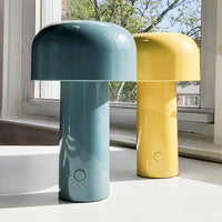 Two modern table lamps: one in calming blue and the other in bright yellow, featuring a glossy finish and smooth curves.