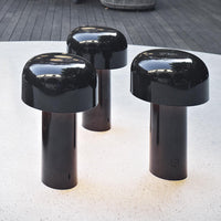 Glossy black mushroom-shaped stools with sleek cylindrical bases, perfect for modern decor.