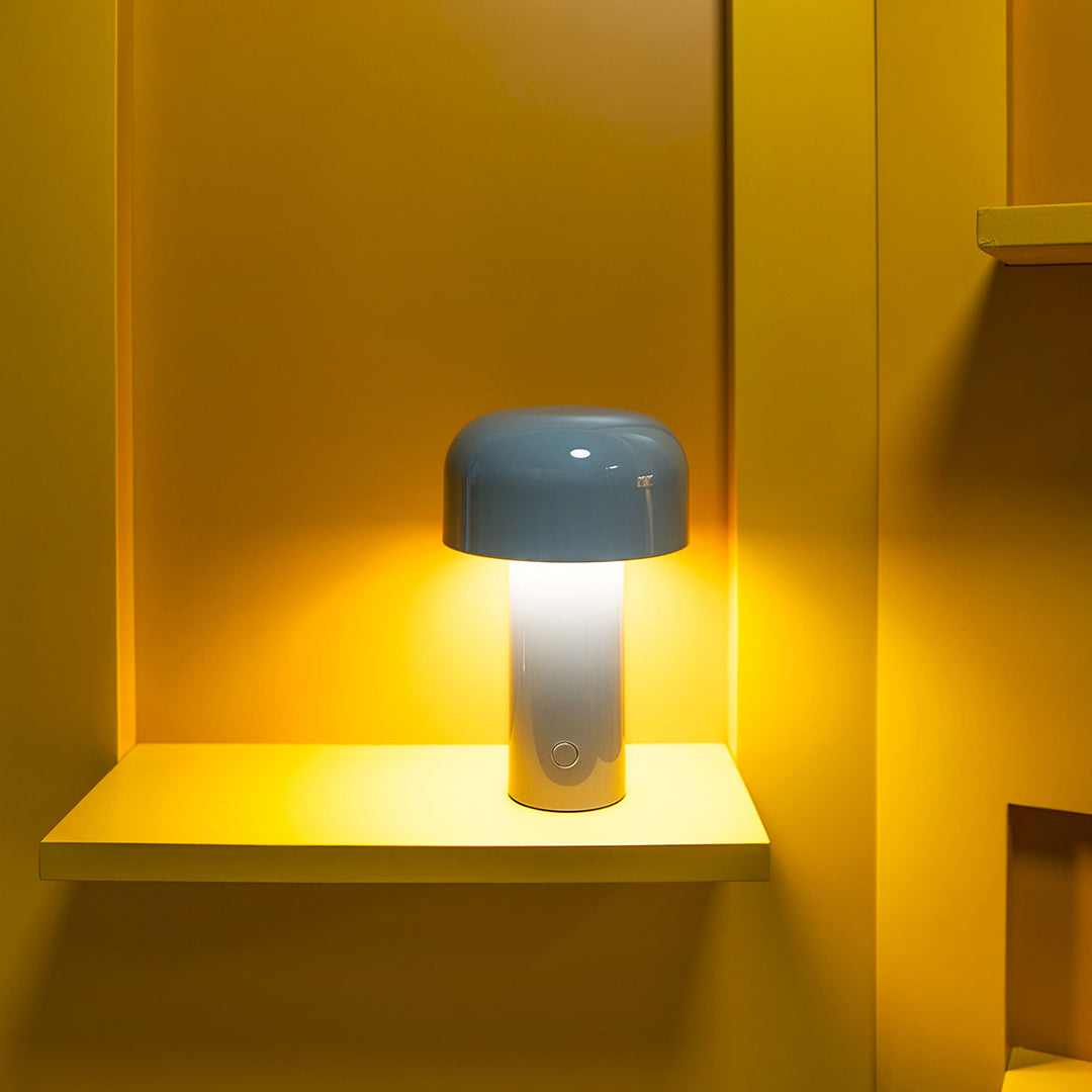 Blue and white lamp with a round shade against a vibrant yellow backdrop and shelf, creating a modern, cheerful aesthetic.