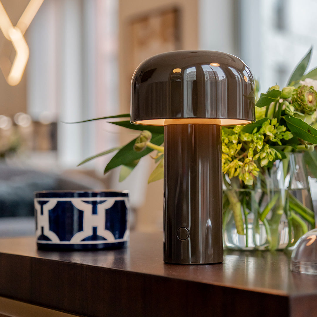Stylish brown table lamp with a glossy finish, paired with a blue and white patterned ceramic vase.