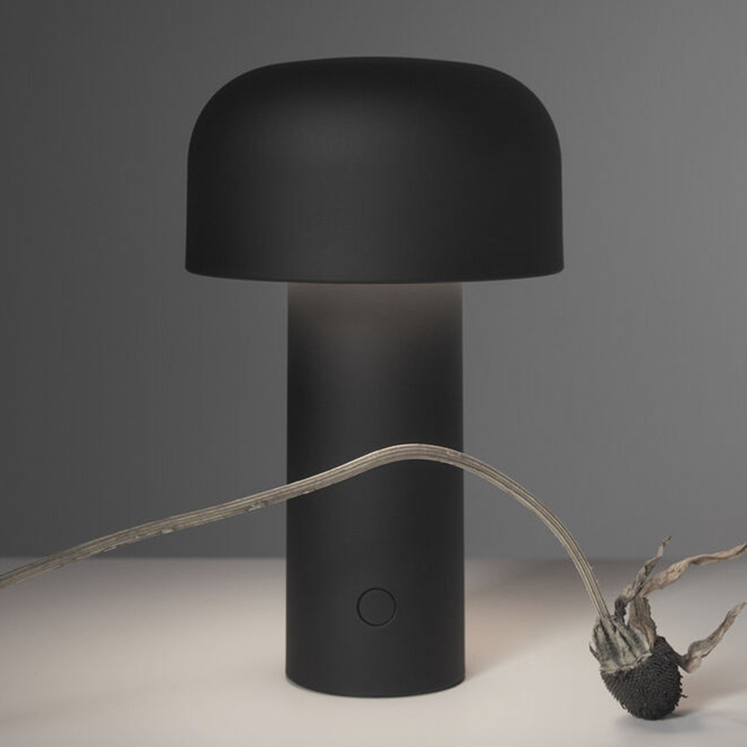"Black mushroom-shaped lamp with a smooth matte finish and soft glow, accentuated by a minimalist design."