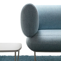 Soft blue fabric sofa with rounded armrest and minimalist design, paired with a sleek white coffee table on a textured teal rug.