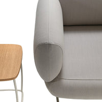 Gray upholstered armchair with a smooth texture next to a light wood side table, featuring clean lines.