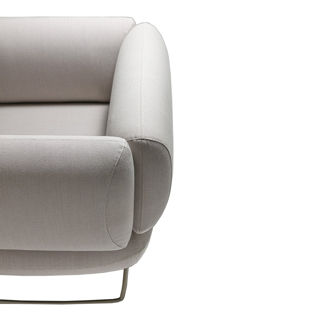 Light gray upholstered armchair with smooth, rounded edges and a minimalist design. Soft fabric, modern look.