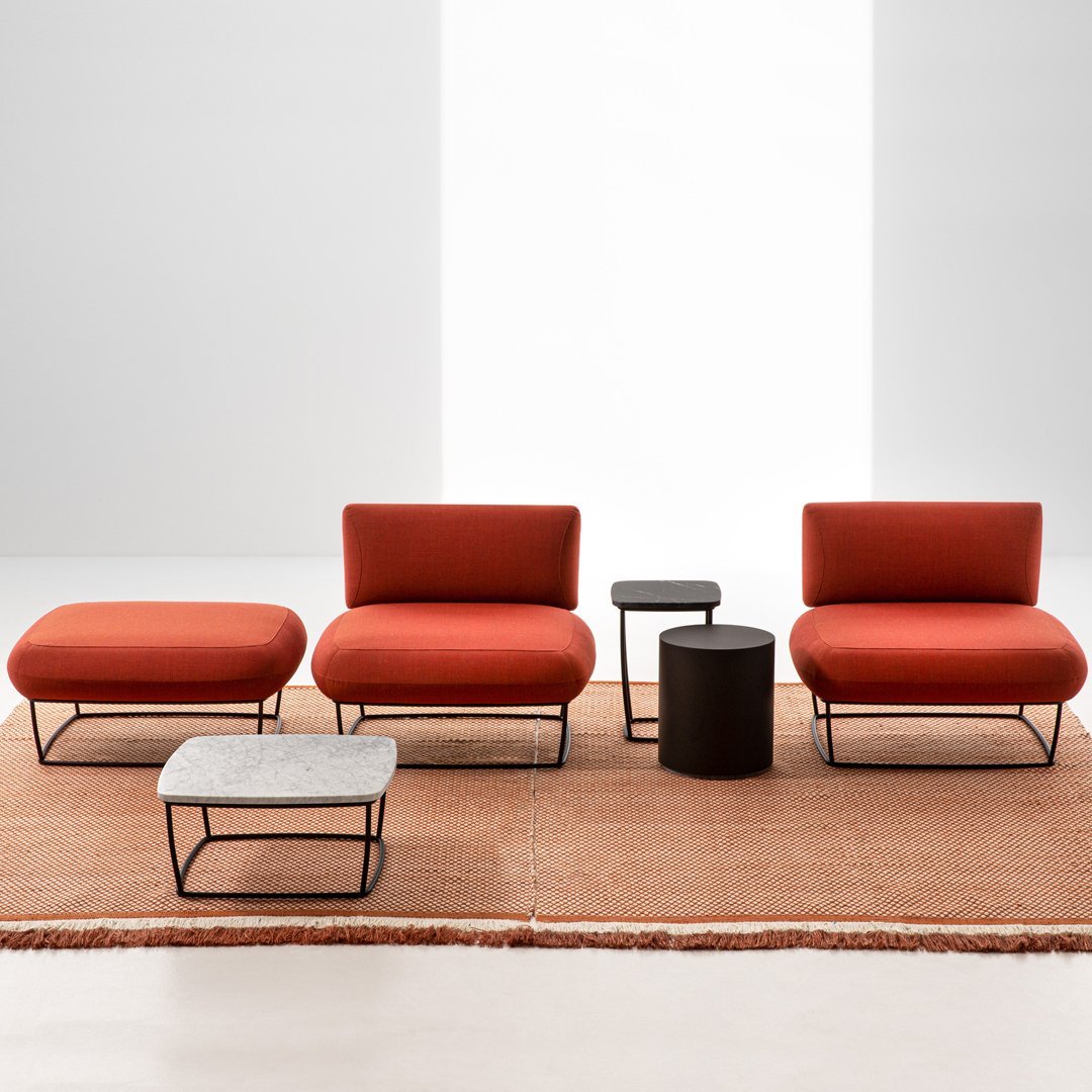 Terracotta seating with minimalist black metal accents atop a natural fiber rug, creating a warm, modern aesthetic.