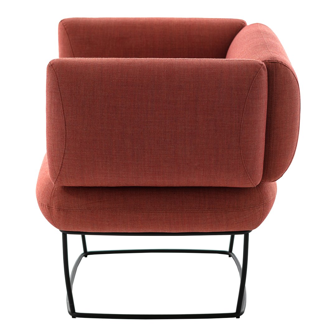 Rust-colored upholstered chair with a modern design and textured fabric, featuring a sleek black metal base.