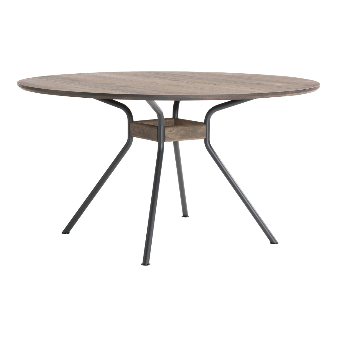 Round wooden dining table with a natural finish, complemented by black metal legs for a modern contrast.