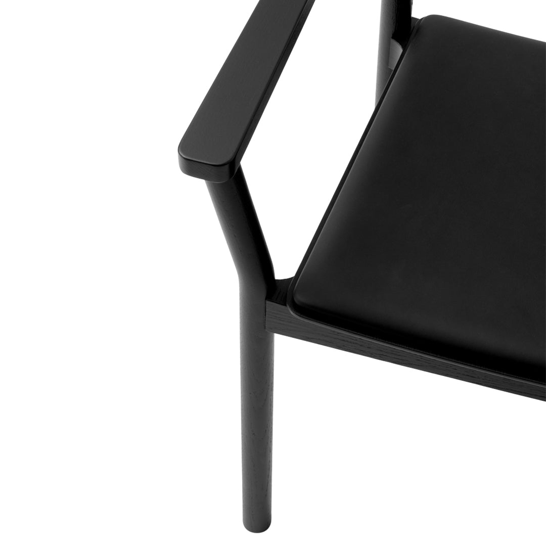 Sleek black chair with minimalist design and smooth surface, featuring a modern black finish and clean lines.