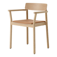Natural wood chair with light oak finish and a tan leather seat, featuring a minimalist design.