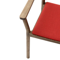 Red fabric cushion on a wooden chair, featuring a clean, minimalist design with natural wood tones.