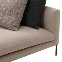 Beige sofa with black and textured brown decorative pillows, showcasing a modern, minimalist design.