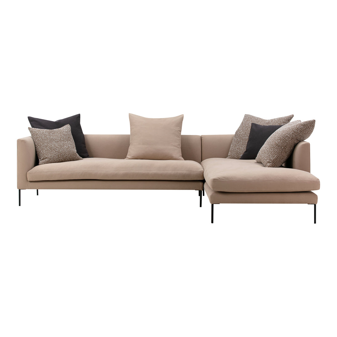 Beige sectional sofa with black and textured gray accent pillows, featuring clean lines and modern design.