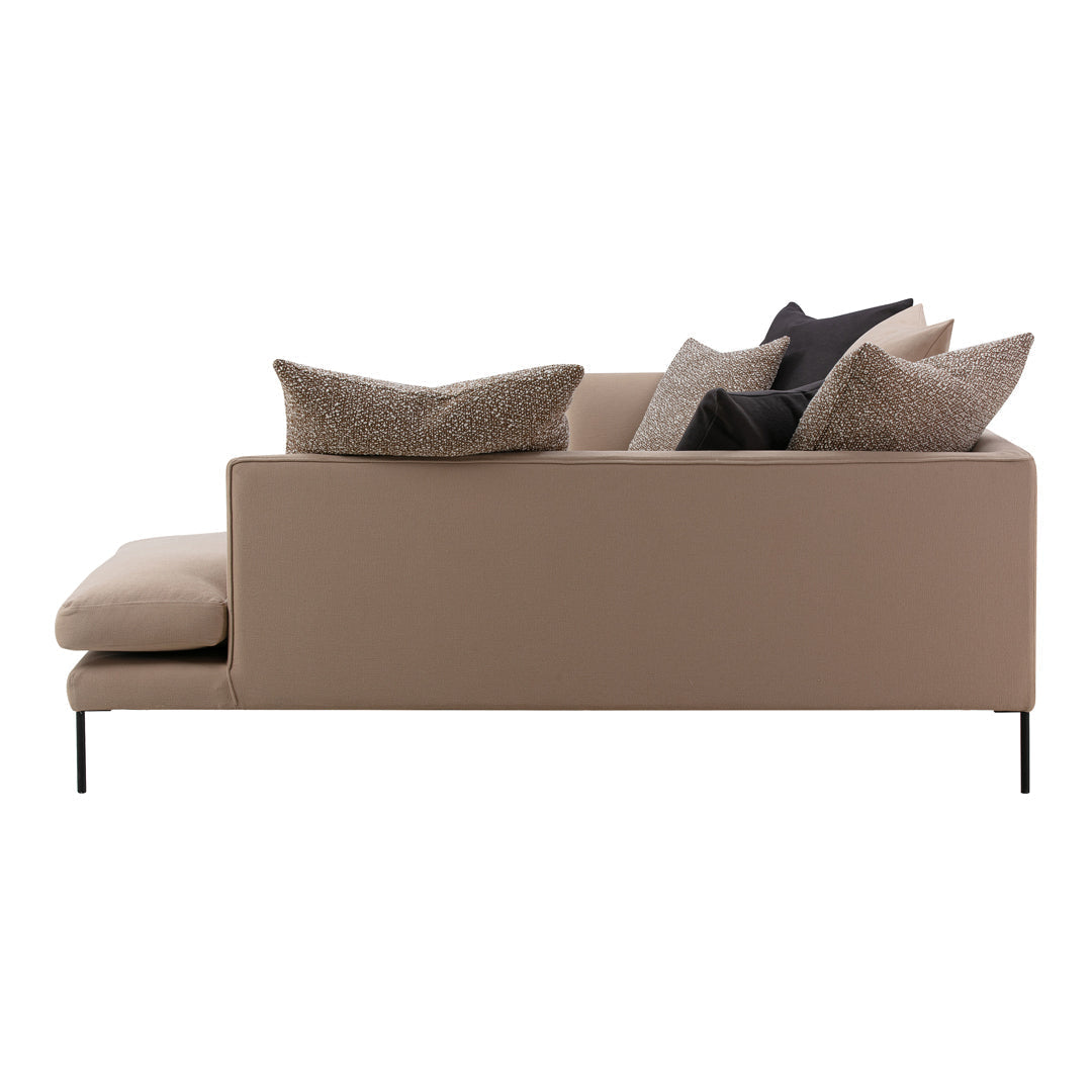Tan sofa with black and patterned throw pillows, featuring sleek lines and modern design elements.