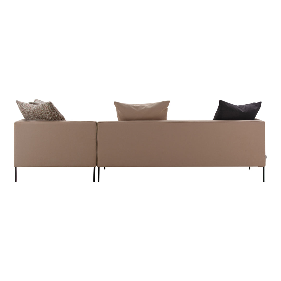 Modern beige sofa with black and grey accent pillows against a minimalist backdrop. Stylish, contemporary design.