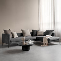 Modern gray sectional sofa with light gray and dark gray cushions, complemented by a black round coffee table.