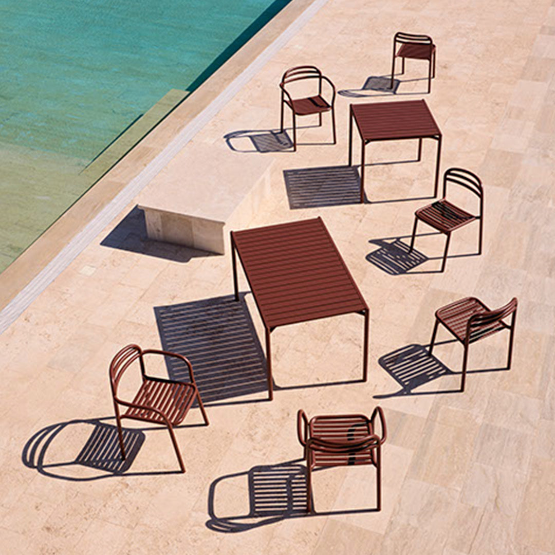 Modern outdoor furniture set featuring a rich rust color with sleek, geometric patterns and distinct shadows.