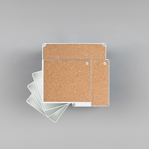 White and cork storage boxes with a minimalist design, set against a soft gray background.